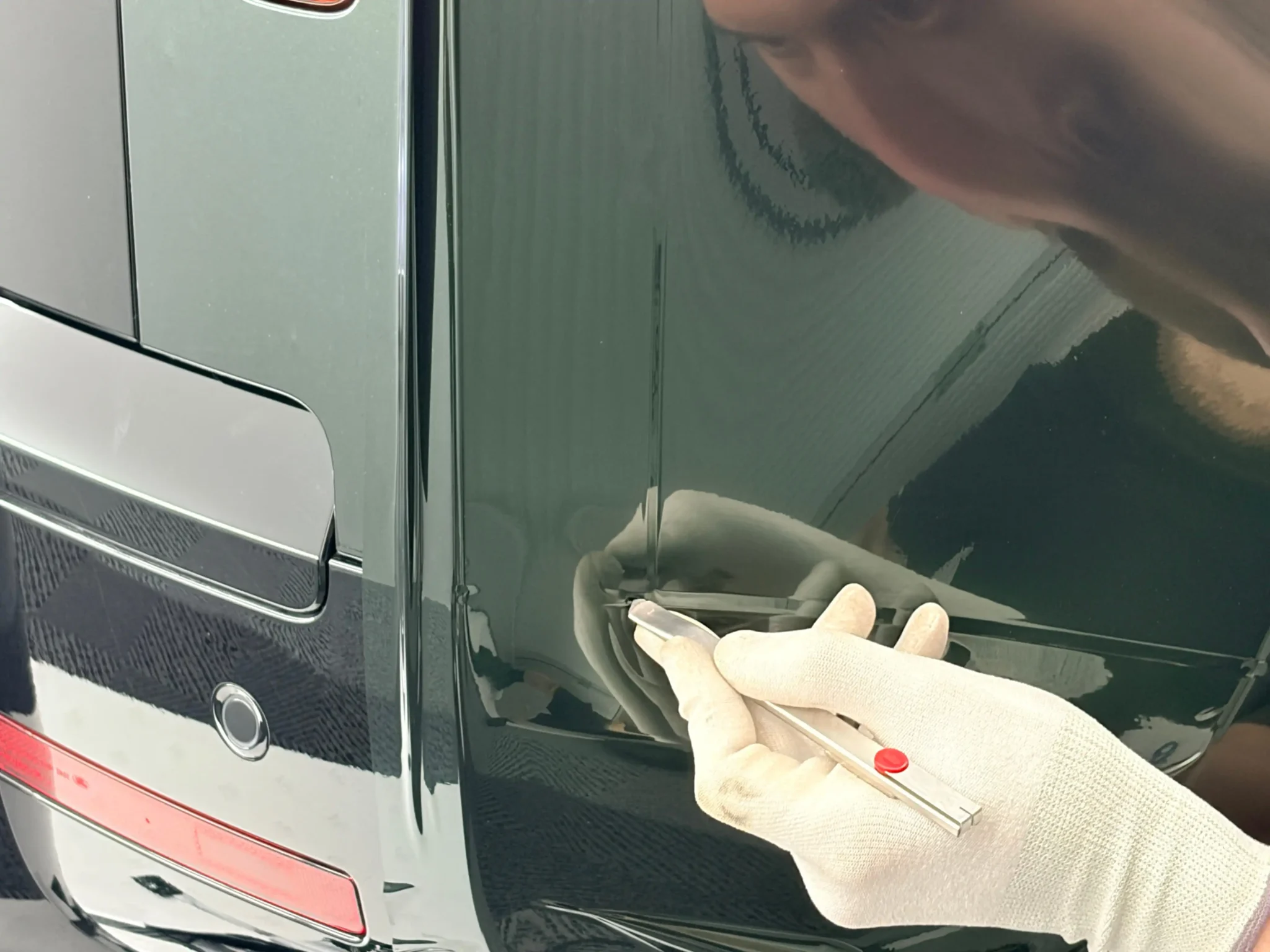 Poseur covering en train de travailler sur la carrosserie d'un véhicule en Belgique